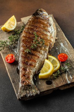 Fırında balık, tuzlu alabalık, ahşap bir tahtada limon, pankart, menü, yazı için tarif yeri, üst görünüm.,