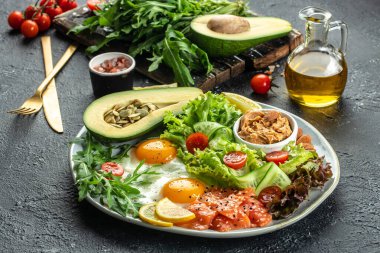 Ketojenik diyet kahvaltı salatası, avokado, balık, yumurta, kurşun geçirmez keto kahveli fındık. metin için yer, üst görünüm.