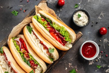 Arka planda sebzeli ve soslu lezzetli sosisliler. afiş, menü, metin için tarif yeri, üst görünüm.