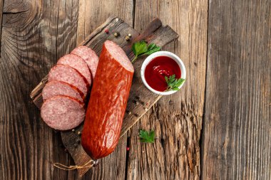 Ahşap arka planda ketçap soslu lezzetli sosisler. afiş, menü, metin için tarif yeri, üst görünüm.