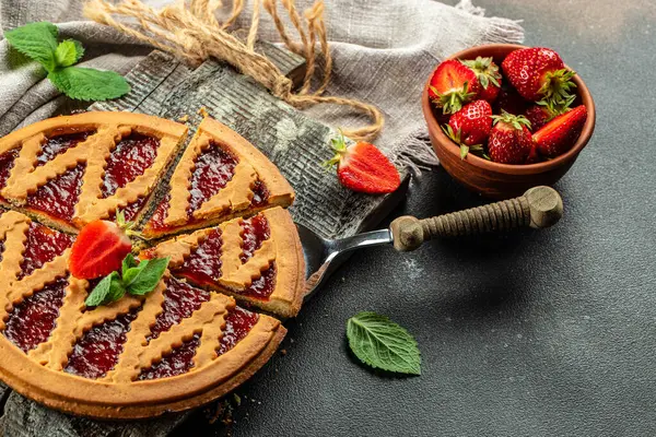 delicious baked Italian jam cake crostata strawberry pie on a dark background. Restaurant menu, dieting, cookbook recipe top view.