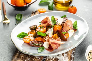 jambonlu jambon, vişneli domates ve fesleğen yapraklı krem peynir, iştah açıcı salata. metin için yer, üst görünüm.