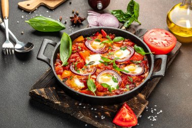 Ev yapımı Shakshouka. Dökme demir tavada servis edilen domates soslu yumurta yemeği, yemek tarifi arka planı. Kapat.,
