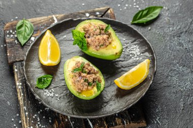 Arka planda ton balığıyla doldurulmuş avokado. Düşük karbonhidratlı yüksek yağlı kahvaltı. Sağlıklı gıda konsepti. metin için yer, üst görünüm.