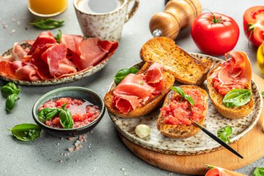 İspanyol kahvaltısı. Jamon Iberico jambonu ve arkaplanda kahve ve meyve suyu olan domates ekmeği. Uzun afiş biçimi. en üstteki görünüm.