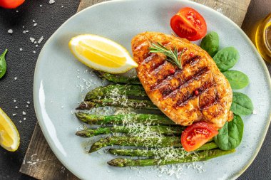 Sebzeli kuşkonmaz ve parmesanlı organik sağlıklı ürünlerle ızgara yapılmış sulu tavuk göğsü. Detoks ve temiz diyet konsepti. metin için yer, üst görünüm,