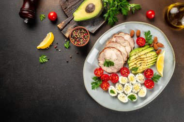 Sağlıklı kahvaltı avokadosu, yumurta, tavuk fileto ve vişneli domates. Keto diyeti, diyet öğle yemeği konsepti. metin için yer, üst görünüm.