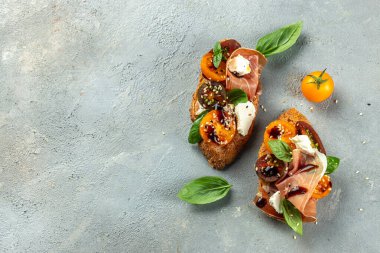 Prosciutto ile bruschetta, kiraz domatesleri fesleğen yapraklı krem peynir, antipasto şarabı. metin için yer, üst görünüm.