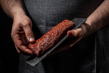 Et pişirmek ve baharat eklemek, arka planda ızgara baharatlı biftek. Restoran menüsü, diyet, yemek kitabı tarifi..