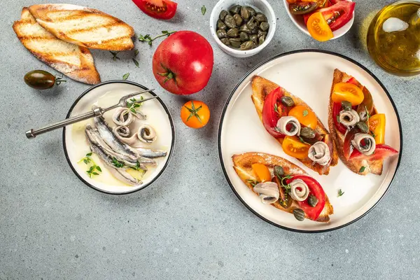 Bruschetta with marinated anchovies, fresh tomato, olive oil. Delicious spanish tapas. banner, menu, recipe place for text, top view.