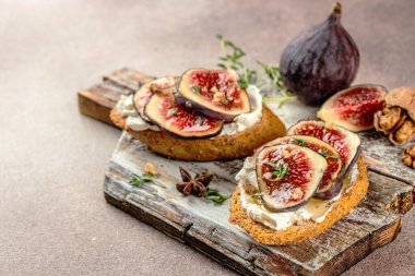 Taze mor incir, ricotta peyniri ve bal ile ahşap bir tahtada, yazı için yer, üst görünüm,