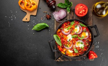 Sağlıklı Shakshuka. Kızarmış yumurta, domates, dolma biber, sebze ve otlar. Orta Doğu geleneksel yemeği..