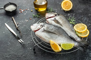 Koyu arkaplanda limonlu iki dorado balığı. afiş, menü, metin için tarif yeri, üst görünüm.