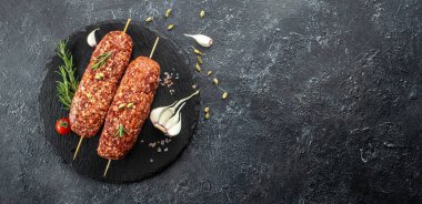 Baharatlı şiş ve ahşap arka planda çiğ Lula kebabı sağlıklı ve dengeli yemek kavramı. metin için yer, üst görünüm,