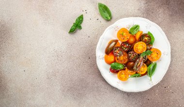 Zeytin yağı ve balzamik sirkeli taze kiraz domatesli salata. Uzun afiş biçimi. en üstteki görünüm.