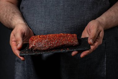 Şefin elleri et pişiriyor ve baharat ekliyor taze çiğ çiğ Angus bifteği. Et pişirme kavramı,