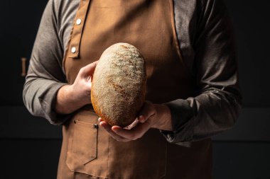 Erkek eli ekmek tutuyor. evcilleştirilmiş fırın pastası. Sağlıklı gıda konsepti. metin için yer.
