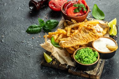 Orijinal geleneksel İngiliz mutfak balığı ve patates püresi, sebze salatası ve tartar sosuyla servis edilir. en üstteki görünüm,