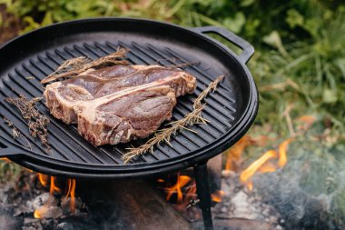 Biftek. Taze çiğ ana Angus bifteği dumanlı ızgarada pişiyor.,