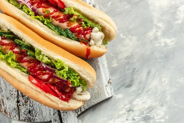 Delicious homemade hot dogs on a light background, banner, menu, recipe place for text, top view.