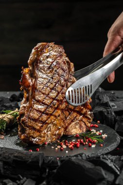 Barbekü ızgara kömürde biftek. Biftek ya da T-Bone bifteği. Restoran menüsü, yemek kitabı tarifi. metin için yer, üst görünüm.