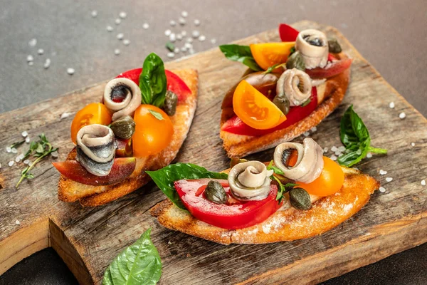 sandwich with marinated anchovies and fresh tomato, olive oil on a wooden board. banner, menu, recipe place for text, top view,