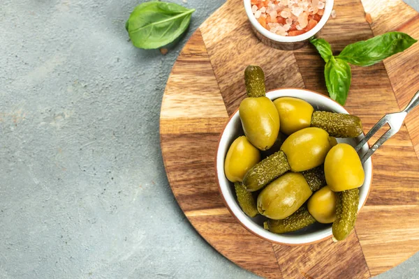 Green olives stuffed with cucumbers on a wooden board. banner, menu, recipe place for text, top view.