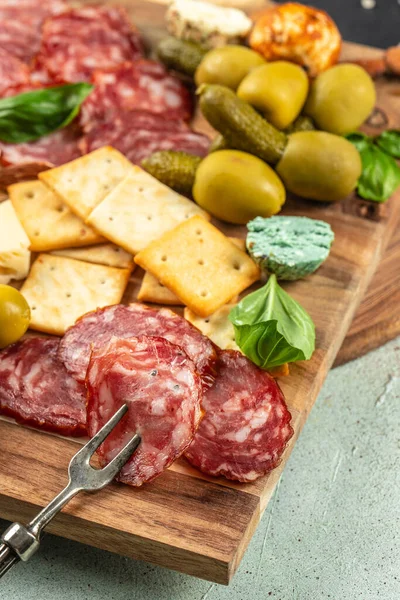 Appetizers table with different antipasti salami, cheese and olives on a light background top view. place for text.