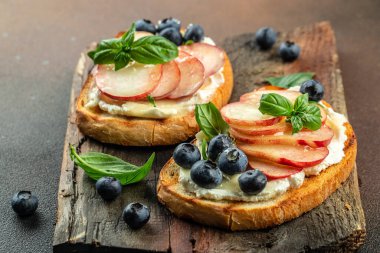 Krem peynirli, ballı, şeftalili ve yaban mersinli lezzetli tost. Sağlıklı ve dengeli beslenme kavramı. metin için yer, üst görünüm.