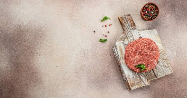 Koyu arkaplanda hamburgerler için çiğ pirzola, restoran menüsü, diyet, yemek tarifi üst görünümü,