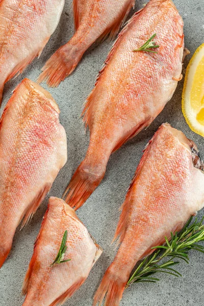 fish, red snapper with lemon, rosemary, salt on a light background. Healthy food concept. place for text, top view.