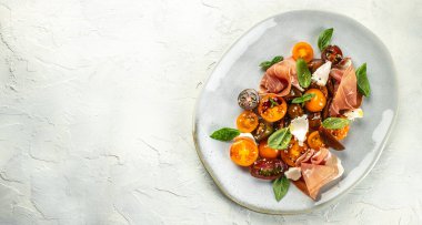 Prosciutto salatası, jambon ve vişneli domates, uzun pankart formatı. en üstteki görünüm,