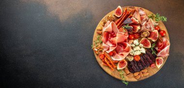 Kurutulmuş jambondan aperatif, incir ve peynirli jambon dilimleri. Akşam yemeği ya da aperatif parti konsepti. Uzun afiş biçimi. Üst Manzara. metin için boşluk kopyala.