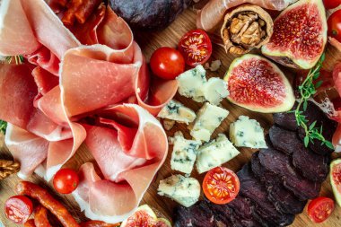 Aperatif tabağı. Kuru jambon, incir ve peynirli jambon dilimleri. Lezzetli dengeli gıda konsepti.