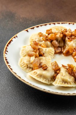 Patates dolgulu vareniki ve kızarmış soğan, arka planda Ukrayna mutfağı. dikey görüntü. Üst Manzara. metin için boşluk kopyala.