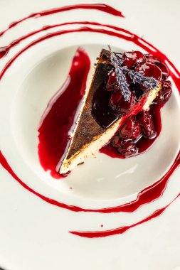 Beyaz tabakta kızılcık soslu cheesecake, dikey görüntü. Üst Manzara. metin için boşluk kopyala.