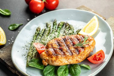 Sebzeli kuşkonmaz ve parmesanlı organik sağlıklı ürünlerle ızgara yapılmış sulu tavuk göğsü. Detoks ve temiz diyet konsepti. en üstteki görünüm.