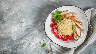 Ptitim makarnalı tavuk göğsü, arka planda kiraz domatesleri ve peynir, uzun afiş formatı. Üst Manzara. metin için boşluk kopyala,