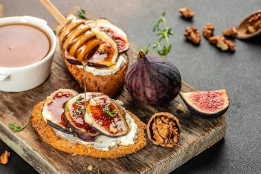 İncirli peynirli bruschetta ve tahtanın üzerinde bal, metin için kopyalama alanı. en üstteki görünüm,