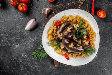 Siyah kanlı sosis ve lahana turşusu kasede koyu bir arka planda. Üst Manzara. metin için boşluk kopyala.