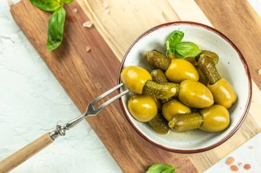 Hafif arka plan manzaralı bir kasede salatalık turşusu olan zeytinler. Boşluğu kopyala.