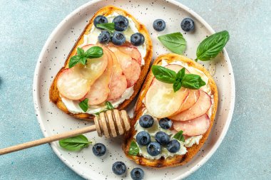 Şeftalili tost, ricotta, ahşap bir tahtanın üzerinde yabanmersini. Yemek tarifi geçmişi. Kapat..