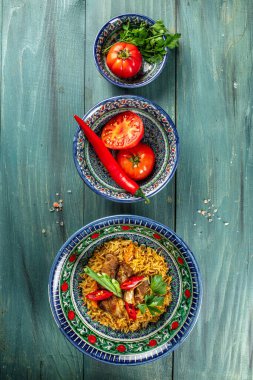 Haşlanmış pirinç, tavuk eti, sebze ve baharat pilavı tabakta, doğu süsüsüyle birlikte, dikey görüntü. Üst Manzara. metin için boşluk kopyala,