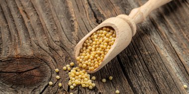 Ahşap bir arka planda ahşap kaşıkta pişmemiş ptitim. Üst Manzara. Boşluğu kopyala,