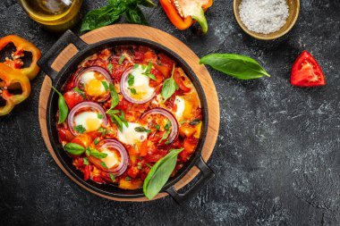 Sağlıklı Shakshuka. Kızarmış yumurta, domates, dolma biber, sebze ve otlar. Orta Doğu geleneksel yemeği..