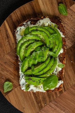 Tahtada avokado, krem peynir ve chia tohumlu lezzetli kepekli tost. Üst Manzara. metin için boşluk kopyala.