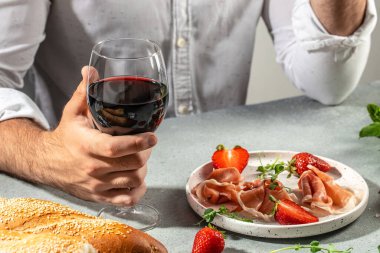 Ellerin bir bardak şarap ve jambon tutuyor Jamon. Antipasti atıştırmalıkları ile aperatifler..