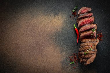 Sulu, orta pişmiş biftek ve koyu bir arka plan. Üst Manzara. metin için boşluk kopyala.