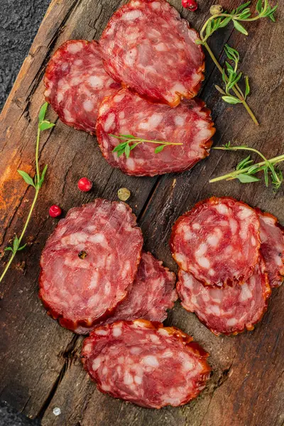 Thinly sliced salami or dry sausage on a wooden background. vertical image. place for text.
