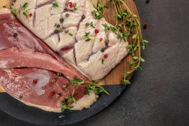 Çiğ ördek göğsü filetosu koyu bir arka planda taze et. Üst Manzara. metin için boşluk kopyala.